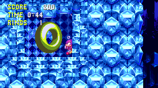 A Knuckles only ring, hidden in the wall underwater. Stay on the first sinking platform that you come to and step off to the left to find the entrance. A spring to return you is just below the entrance.