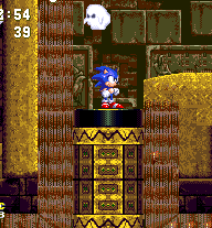 Should you simply drop down the shaft, you'll probably land below the edge of the pillar platform, which will be too high for you to reach (if you're Sonic). In this particular case, you can find an alternate route by heading to the left. Step into the right hand sandfall here, when on this platform..